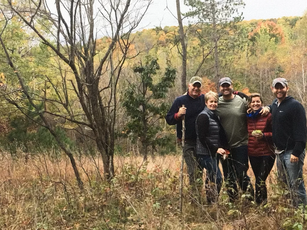 Photo of John in the fall Michigan woods with family.